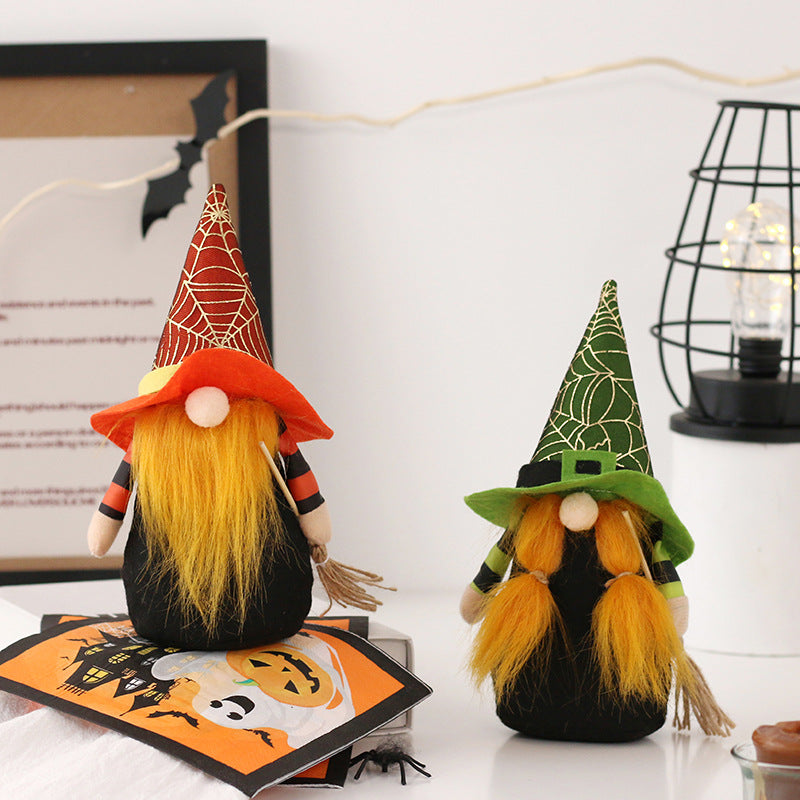 Two Halloween gnomes with orange beards and striped sleeves stand side by side. One wears a red wizard hat with a gold web, while the other dons a green hat with a web pattern and belt. They hold small brooms and are set against a backdrop with festive decorations, including a bat cutout and string lights.