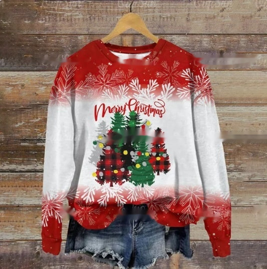 Red and white Christmas sweater with "Merry Christmas" text, featuring decorated trees in plaid patterns. Snowflake designs on sleeves. Paired with denim shorts on a wooden background.