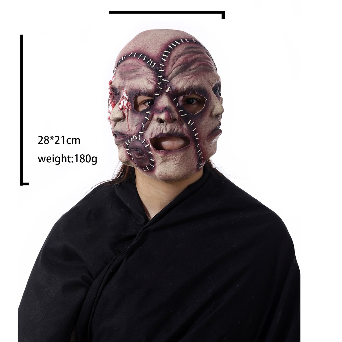 A person wears a grotesque horror mask with stitched-together faces and scars. The mask dimensions are 28x21cm and it weighs 180g. The person is draped in black fabric.