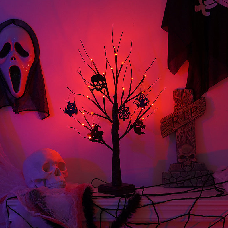A spooky Halloween scene with a red-lit tree adorned with bats and skulls, beside a skull and a "RIP" tombstone. A ghost mask and cobwebs complete the eerie decoration.