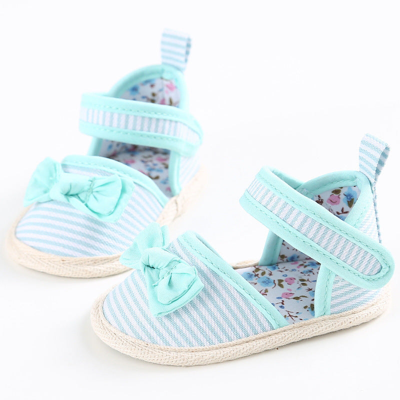 Light blue and white striped baby shoes with fabric bows and floral interior. The velcro straps provide easy closure, while soft soles ensure comfort.