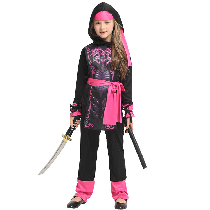 A young girl in a black and pink ninja costume holds a sword and nunchucks. She wears a hood, headband, and a sash, with pink accents on her attire and shoes.