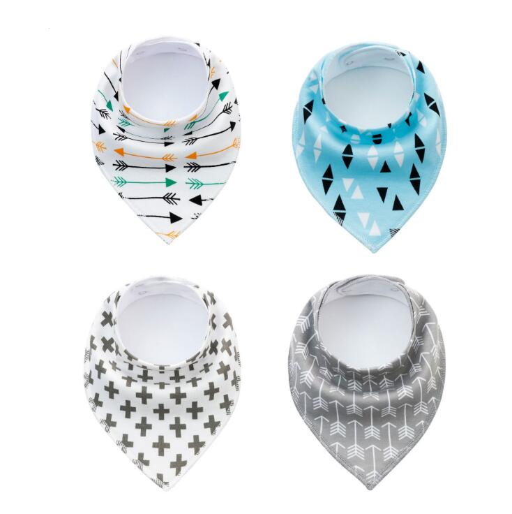 Four baby bibs with different patterns: arrows on white, triangles on blue, crosses on white, and arrows on gray. Each is shaped like a drool bandana.
