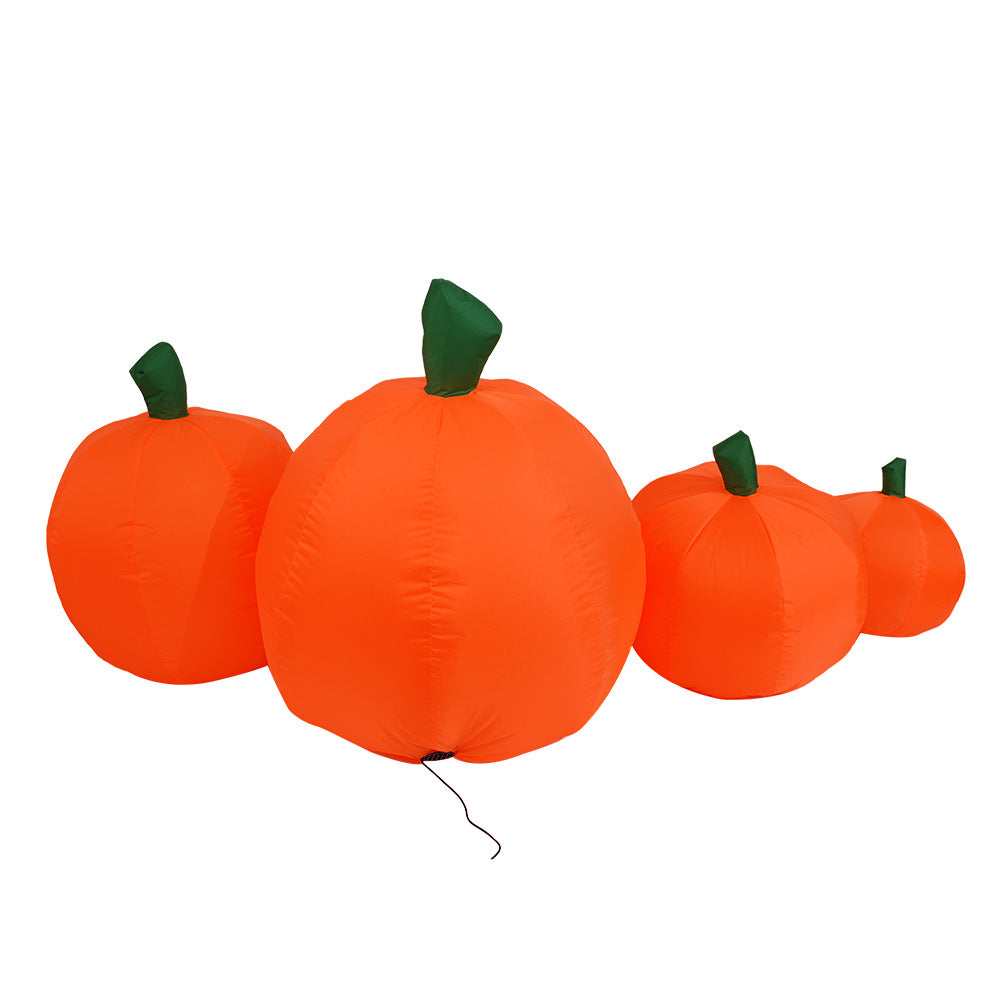 Four inflatable orange pumpkins of varying sizes with green stems are set against a white background, capturing a festive, seasonal decoration.