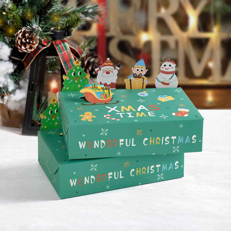 Green festive boxes with "Xmas Time" and "Wonderful Christmas" text, decorated with Santa, elf, snowman, and tree cutouts. A pine tree and lantern adorn the background.