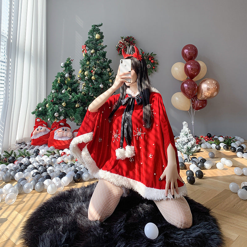Person in a festive red outfit and reindeer headband taking a selfie in front of decorated Christmas trees. The room is adorned with balloons and Christmas ornaments.