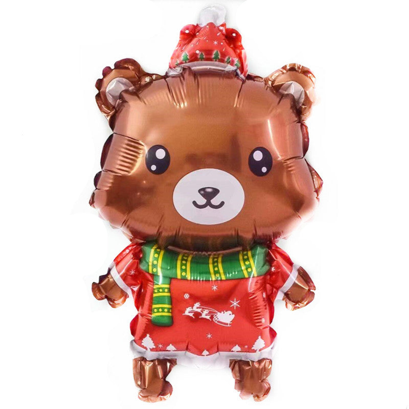 A shiny teddy bear balloon wearing a red Christmas outfit with a green scarf, decorated with festive patterns including Santa and reindeer.