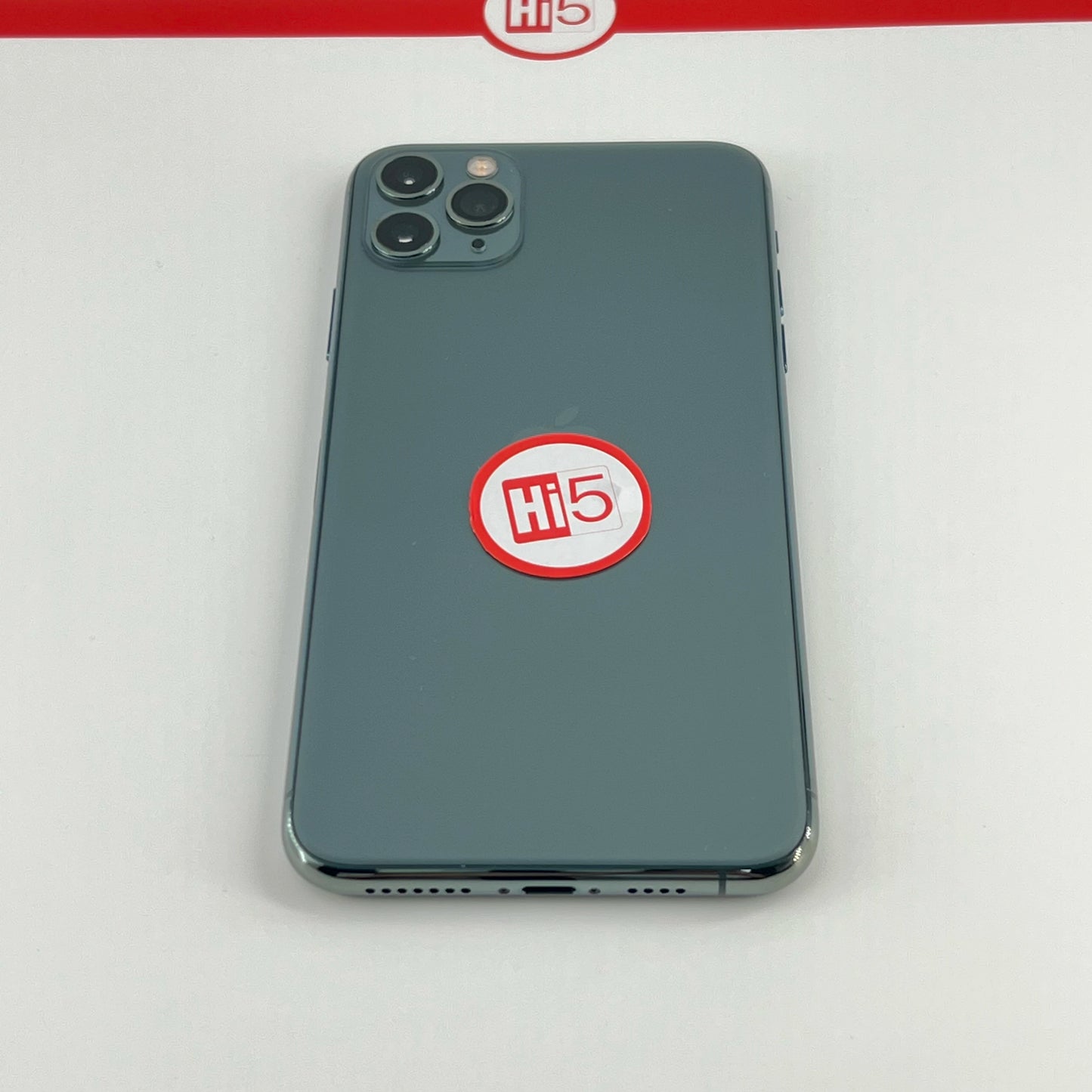 A smartphone with a triple camera setup is placed face-down. It has a circular "Hi 5" sticker on the back, and a similar logo is visible on a strip above.