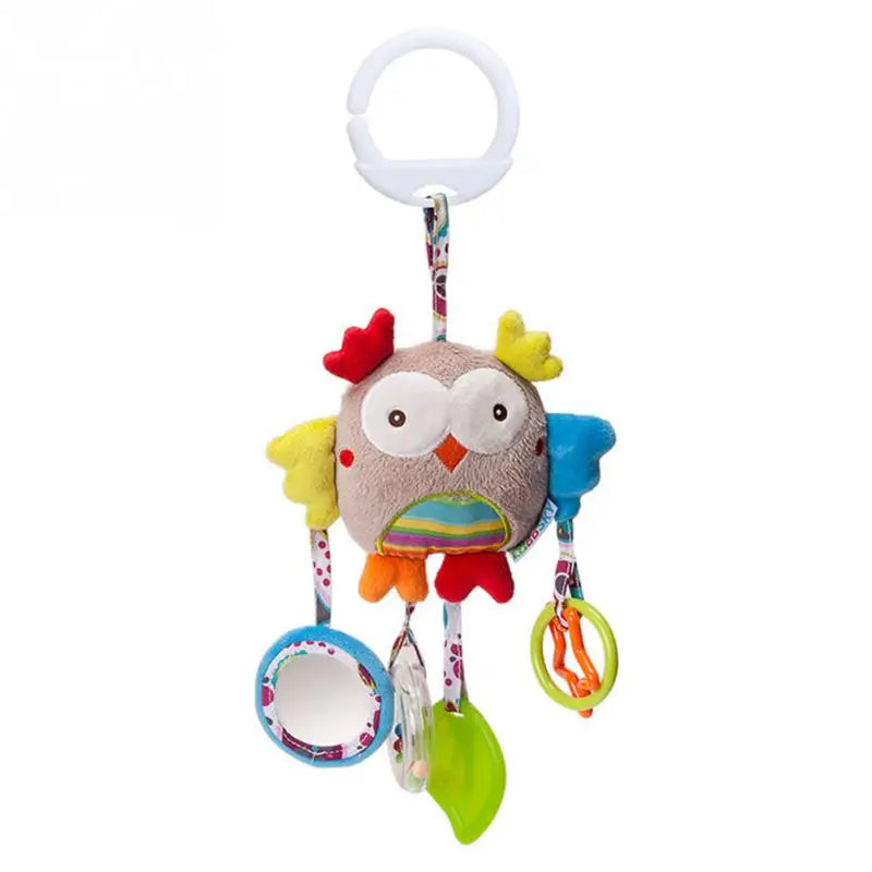 Colorful plush owl baby toy with large eyes, red and yellow wings, and various hanging elements including a mirror, rings, and a teether. Attached to a ring for hanging.