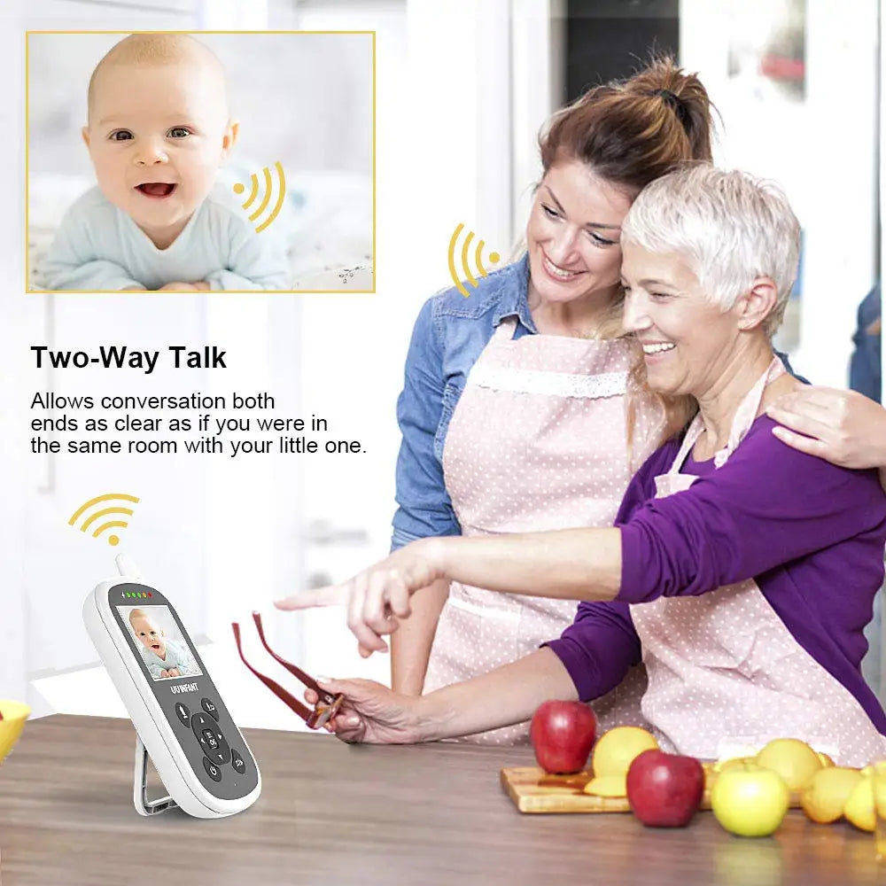 Women wearing aprons smile and point at a wireless baby monitor displaying an infant. Text highlights "Two-Way Talk" feature, allowing clear conversation with the baby.