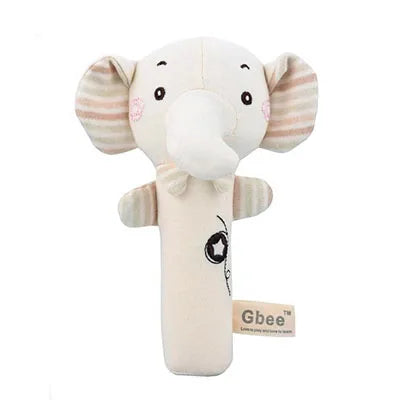 Soft elephant-shaped baby rattle with light pink striped ears and cheeks. Beige fabric body features a simple black design and a "Gbee" tag. Ideal for infant sensory play.