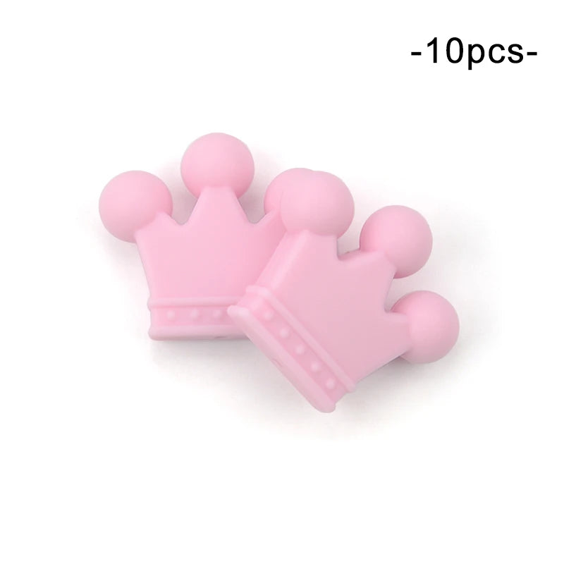 Two pink silicone crown-shaped teething toys, designed for infants, with rounded tips and dotted details. Text above reads "10pcs," indicating a set of ten pieces.