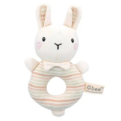 Plush bunny rattle with a ring body featuring pastel stripes. The toy has embroidered eyes and nose, blushing cheeks, and a bow tie, with "Gbee" label on the side.