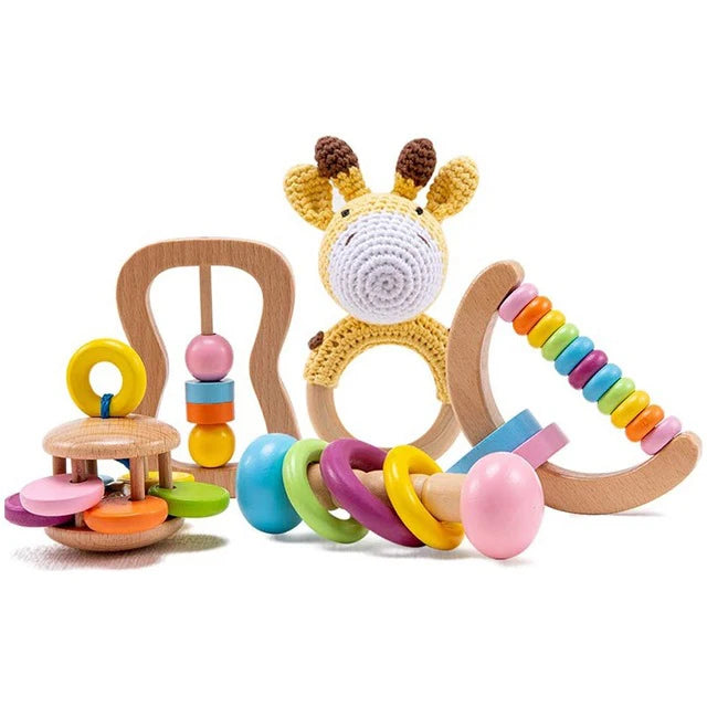 A set of wooden and crochet baby toys, including a giraffe teether, rainbow bead ring, abacus, and spinning rattle, all featuring colorful elements and playful designs.
