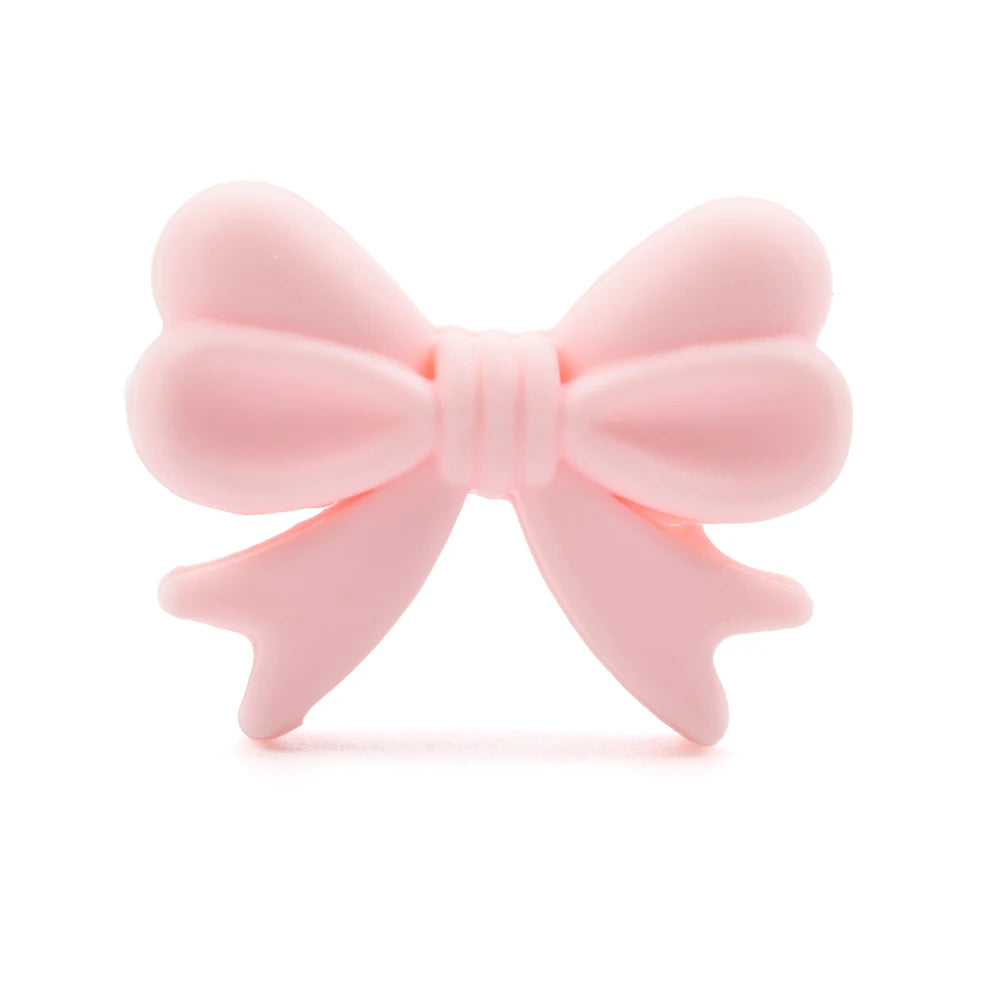 A pastel pink bow with smooth, rounded loops and tails, displayed against a white background. The bow is simple, elegant, and symmetrical, resembling a ribbon.