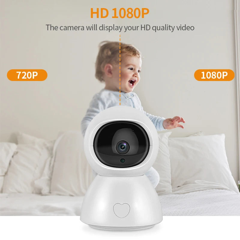 White baby monitor camera in the foreground with a heart design, showcasing HD 1080P video quality. A happy baby is in the background on a bed.