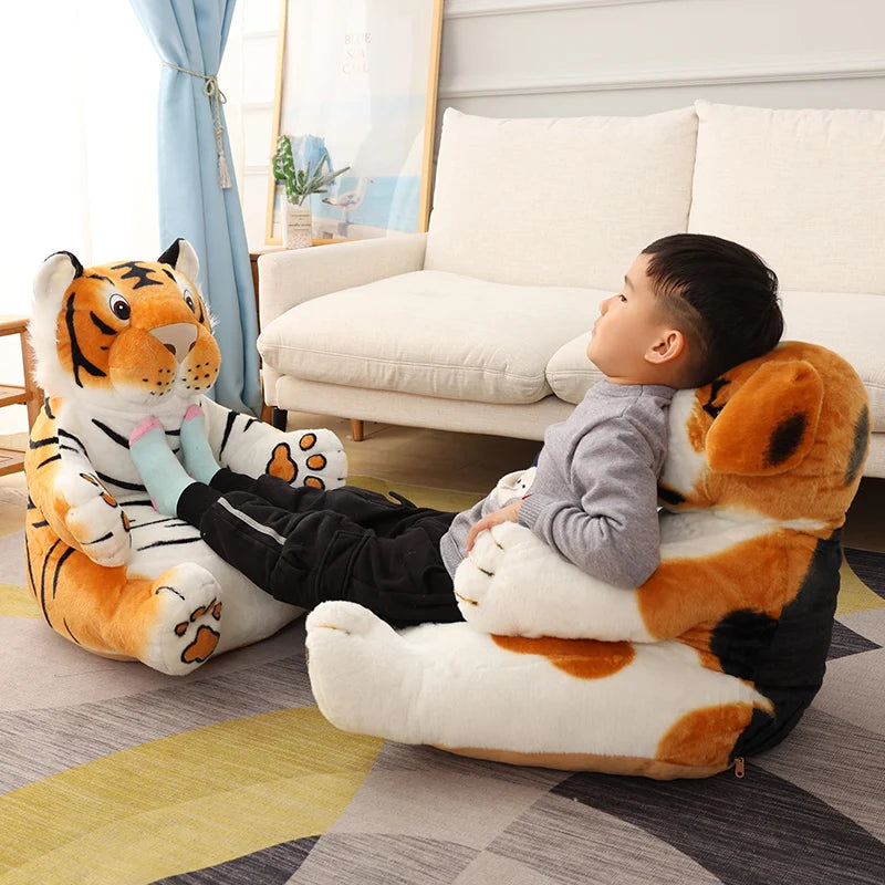 A child reclines against a large dog plush while resting feet on a big tiger plush, relaxing in a cozy living room with a sofa, blue curtains, and decorative items.