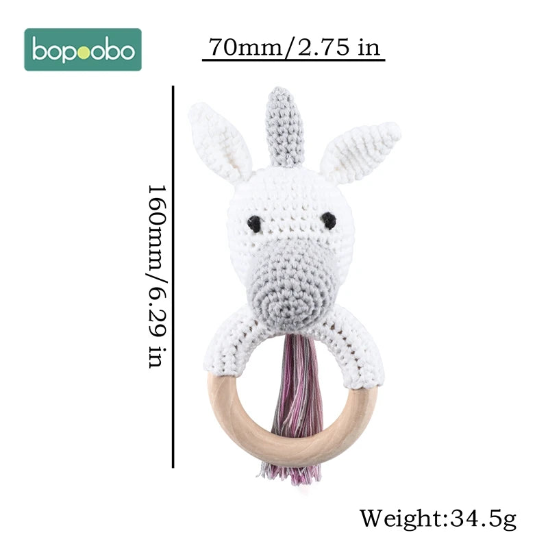 Crocheted white animal rattle with a wooden ring handle, featuring a gray snout and ears. It measures 160mm tall and 70mm wide, with a weight of 34.5g. Brand logo: Bopoobo.