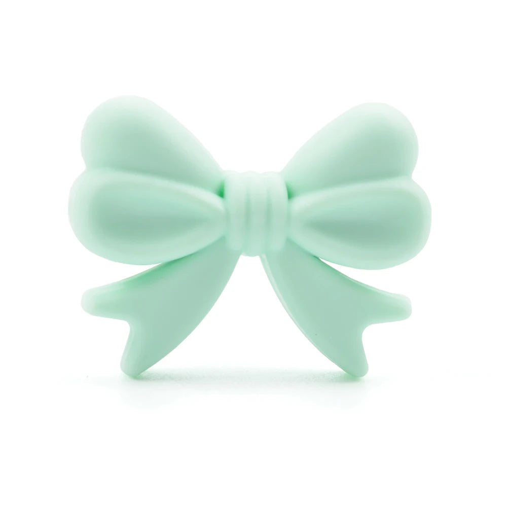 A mint green bow-shaped object with symmetrical loops and tails on a white background, showcasing a smooth, matte texture.
