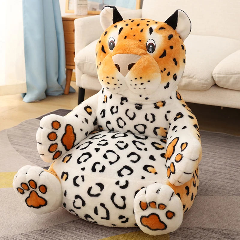 A plush leopard chair with a smiling face and spotted fur is placed on a gray rug in a cozy room, featuring a beige sofa and light blue curtains in the background.