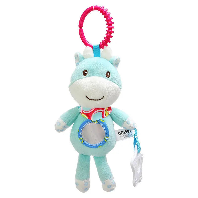 Soft blue plush toy with a smiling face, colorful scarf, and a clear circle on its belly. Attached is a red plastic ring and a white teething accessory on a blue string.