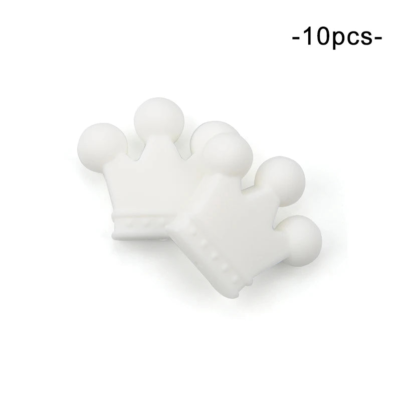 Two white crown-shaped silicone teethers with rounded tips, stacked slightly on top of each other. The text above reads "-10pcs-".