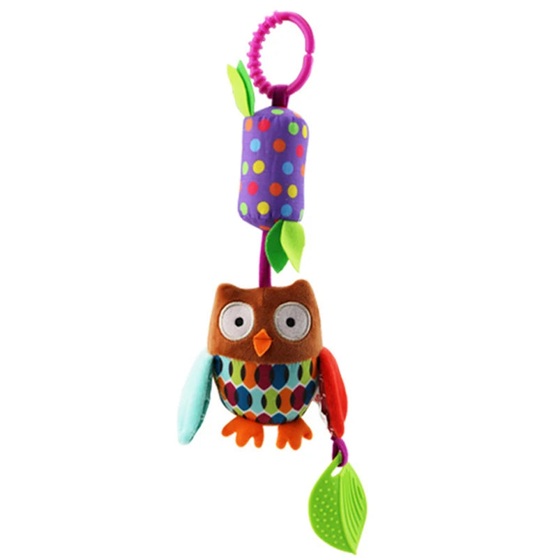 Colorful plush owl toy with a purple polka-dot cylinder and green leaf attached by a pink loop. The owl features multicolored wings, a patterned belly, and orange feet.