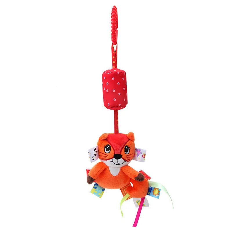 Colorful plush squirrel toy with a red hanging strap. Features a red cylinder with white stars above, and ribbon tags on its sides for sensory play.