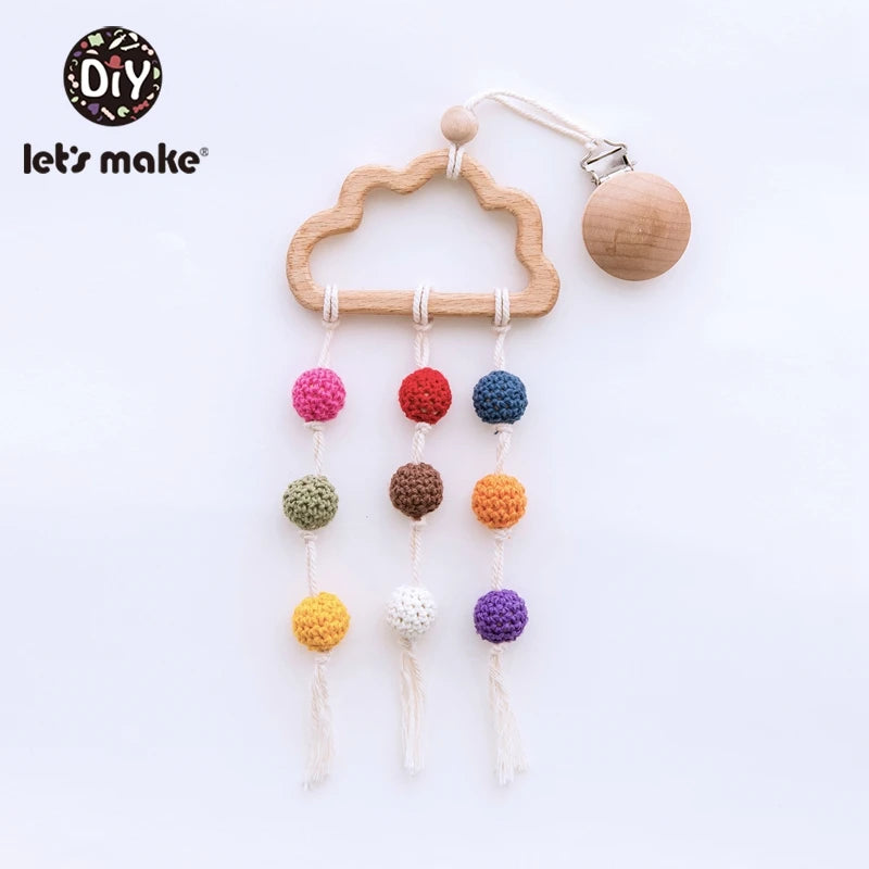 Wooden cloud baby mobile with colorful crochet balls hanging on strings. The mobile includes a wooden clip attached by a white cord. Suitable for nursery decoration.