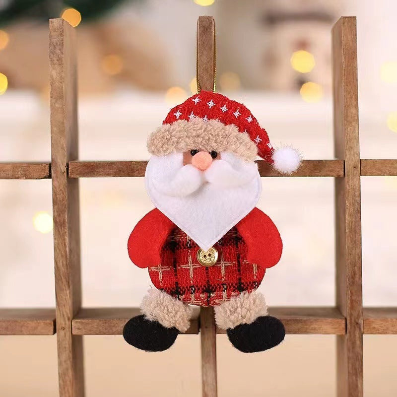 Plush Santa ornament in red and white attire with a fluffy beard and hat, sitting on a wooden shelf. Background has blurred warm lights, creating a festive atmosphere.