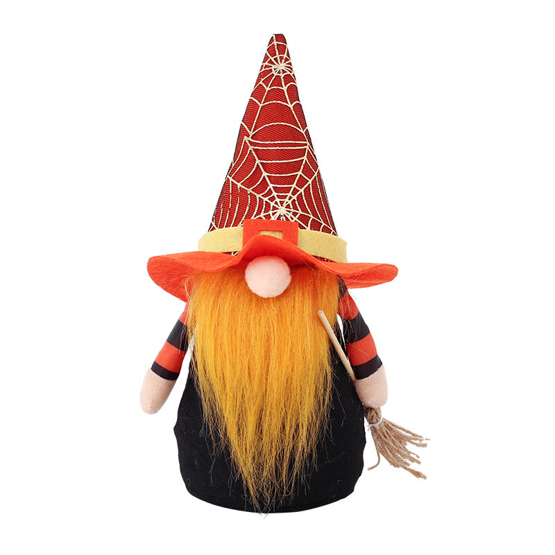 A whimsical gnome figure dressed in a black costume with red-striped sleeves, featuring a long orange beard. The gnome wears a tall red hat with a web pattern and a wide-brimmed orange hat. It holds a small broom in one hand, evoking a playful Halloween theme.