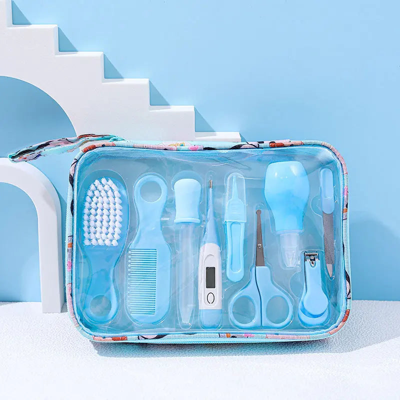 A compact baby grooming kit in a clear case, containing a blue brush, comb, nasal aspirator, thermometer, scissors, and nail clippers, set against a light blue background.