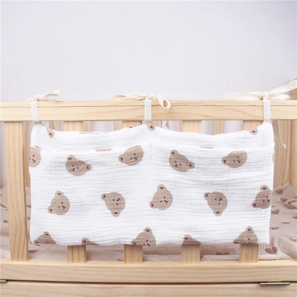 Soft crib bumper with cute brown bear faces on white fabric, tied to a wooden crib with beige ribbons.