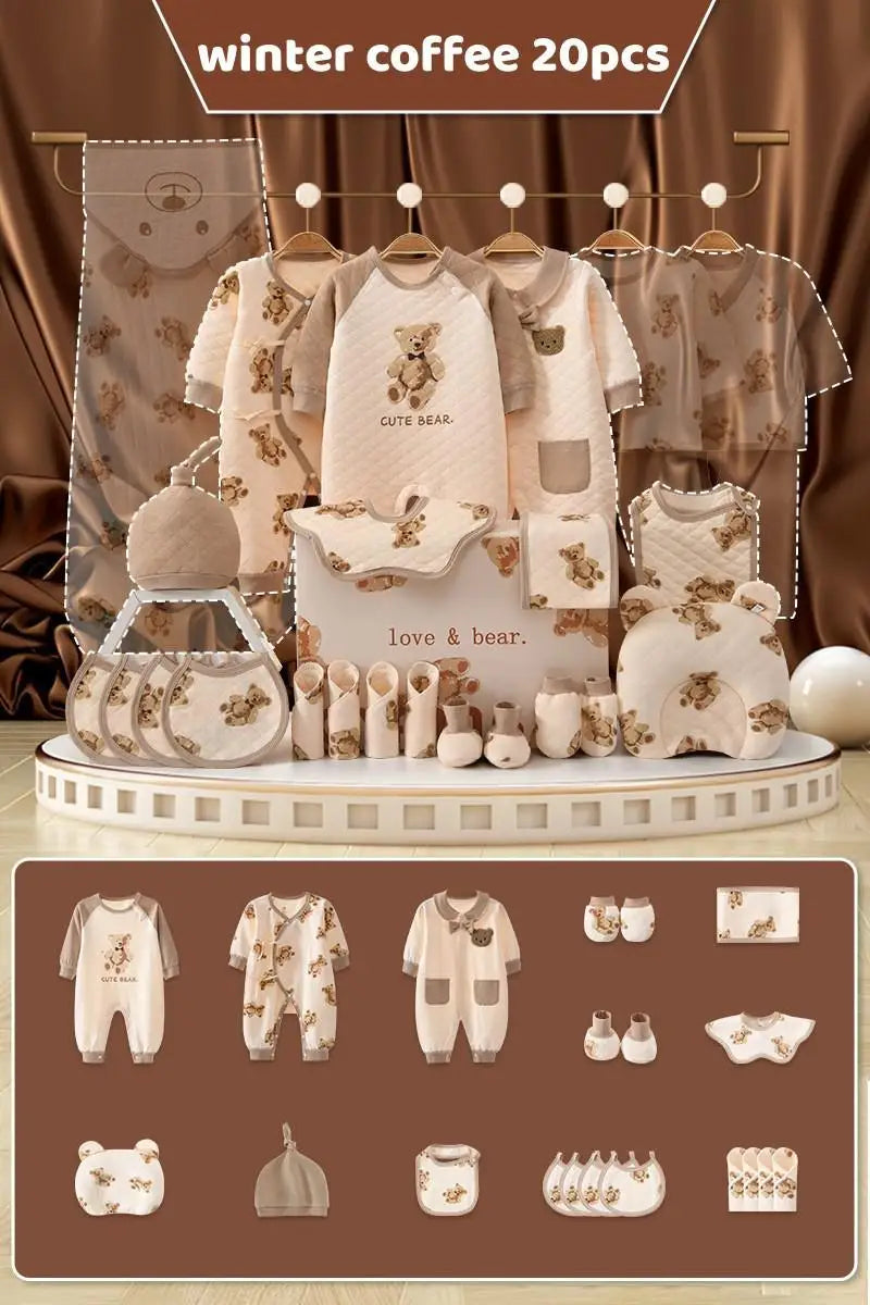 Baby clothing set in soft brown tones with teddy bear designs. Includes onesies, bibs, booties, a hat, and accessories, displayed on a stage with a silky brown backdrop.