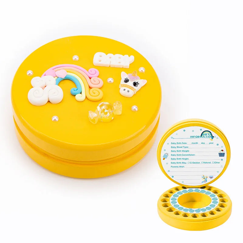 Round yellow keepsake box with decorations: rainbow, cow, "Baby" text, pearls, candy. Open view shows baby info form and tooth slots inside.