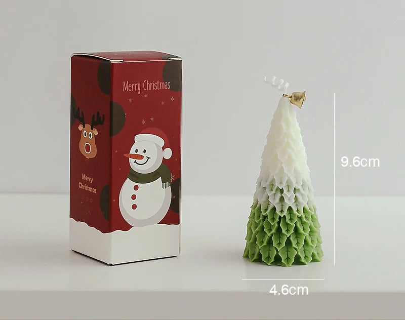 Christmas tree candle with green and white layers, 9.6 cm tall, and a star on top. Stands beside a red box featuring a snowman and reindeer, labeled "Merry Christmas."