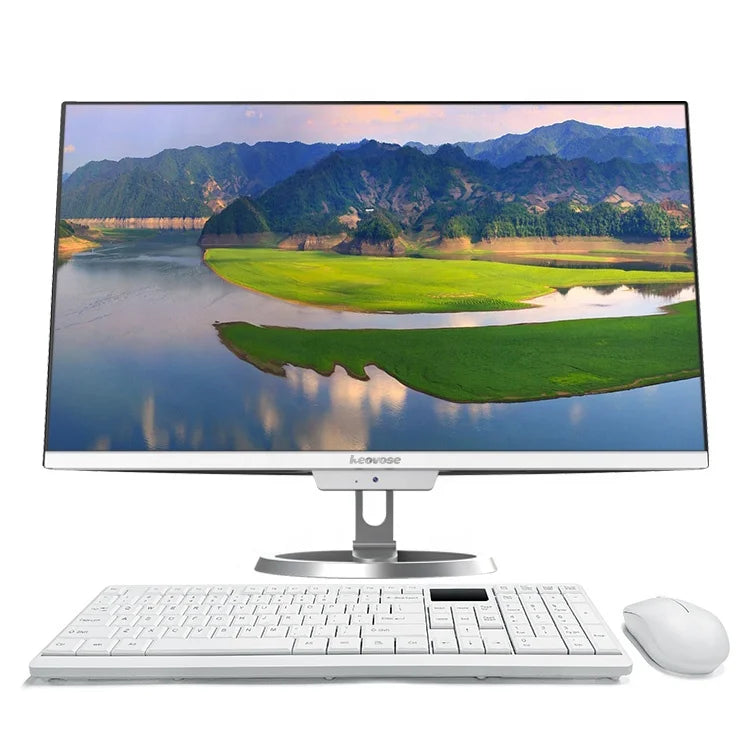 A sleek computer setup with a widescreen monitor displaying a scenic landscape of mountains, water, and greenery. A white keyboard and mouse are placed in front.