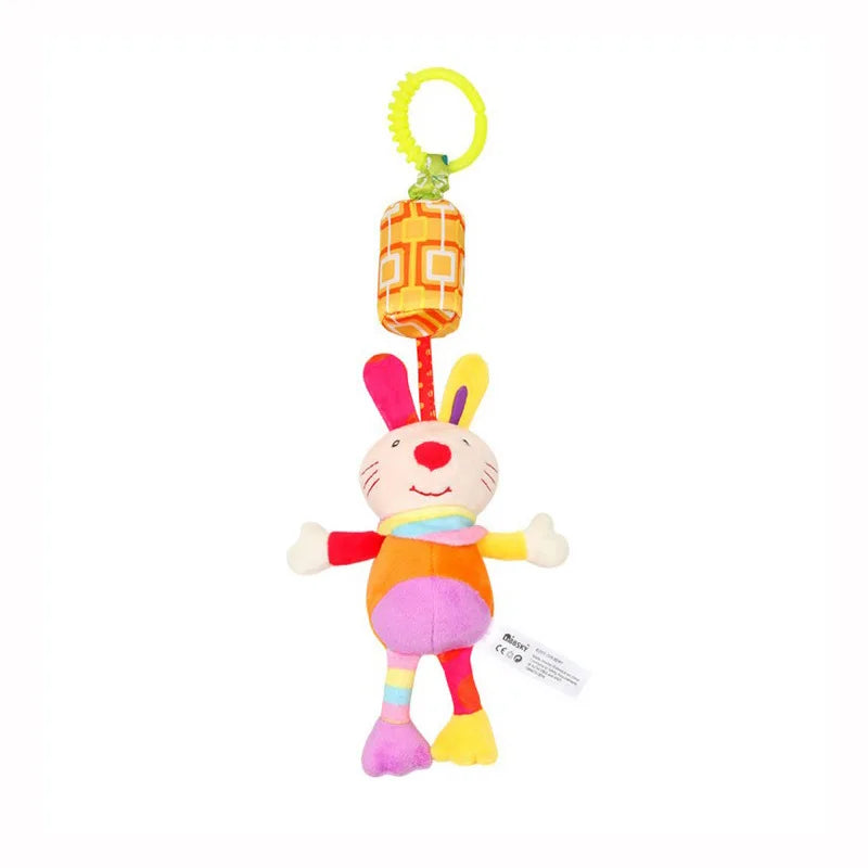 Colorful plush rabbit toy with a smiling face, featuring multicolored ears and body. It hangs from a yellow ring via a fabric strap with an orange geometric pattern block.