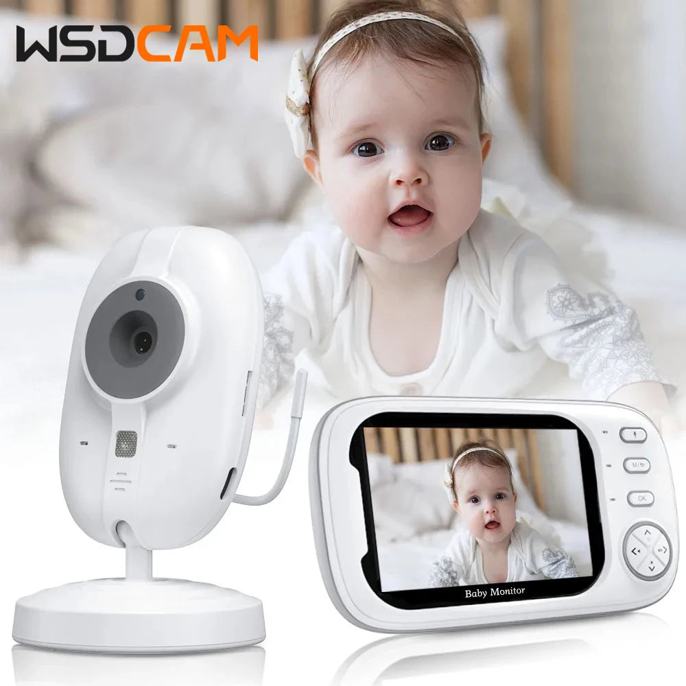 A baby monitor setup featuring a baby in a white outfit on the screen. The monitor and camera are white with control buttons visible, set against a blurred background.