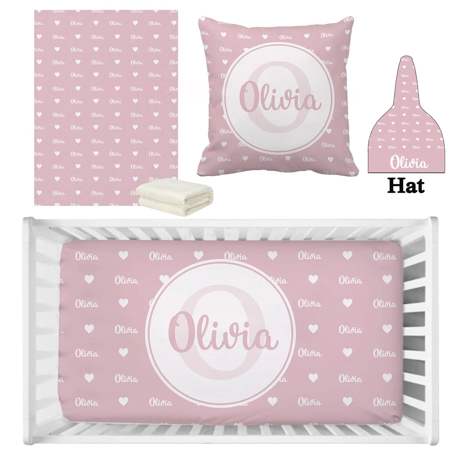Pink nursery set with a blanket, pillow, hat, and crib sheet featuring white hearts and personalized name "Olivia" in cursive. Sheets beside folded white fabric.