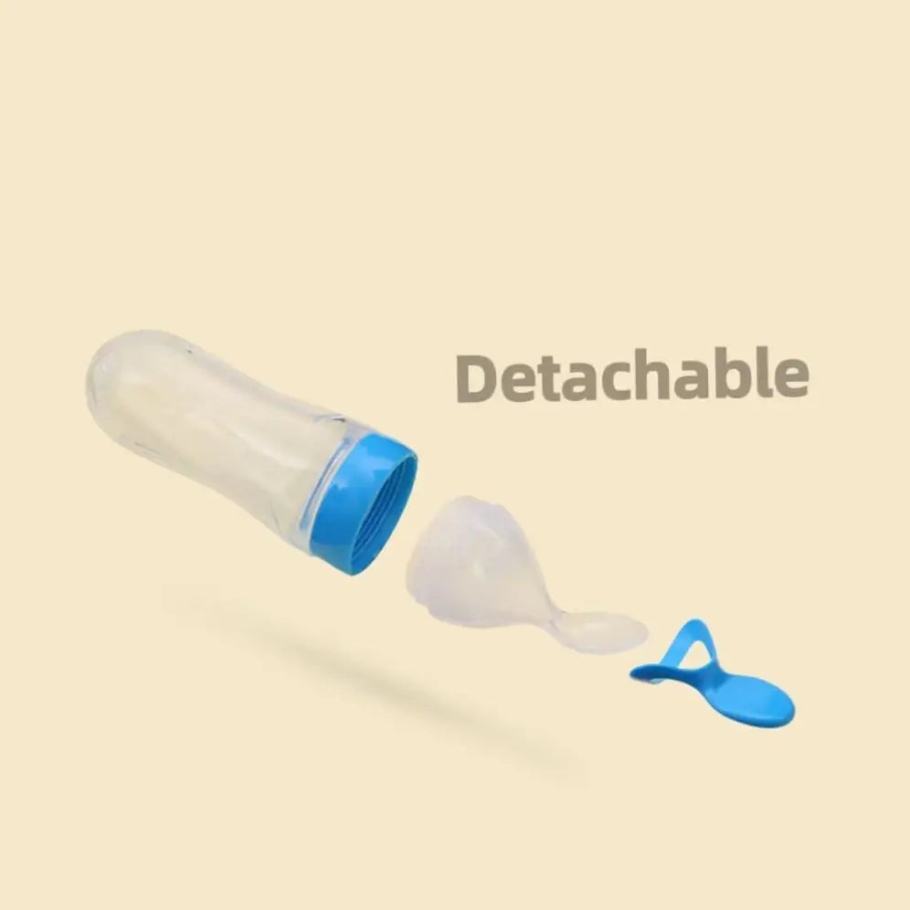 Transparent bottle with a blue cap, detachable spoon attachment, and a silicone cover, on a beige background. Text reads "Detachable" in bold letters.