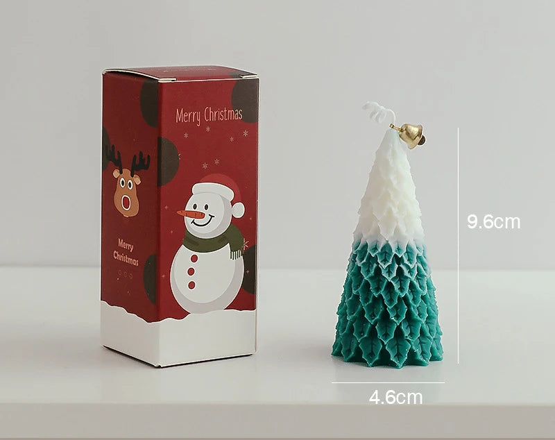 Christmas tree candle with a white top and teal base, adorned with a gold bell, measuring 9.6cm tall and 4.6cm wide. Box features a snowman and reindeer design with "Merry Christmas."