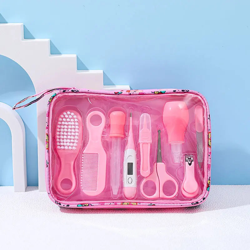 Pink baby care kit with a hairbrush, comb, medicine dropper, thermometer, scissors, nail clipper, and other grooming tools in a transparent zippered case on a blue background.