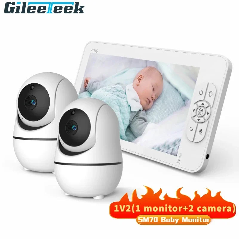 Two white cameras and a baby monitor showing a sleeping baby. The device features a 7-inch HD screen and controls, with text "1V2 (1 monitor + 2 camera) SM70 Baby Monitor."