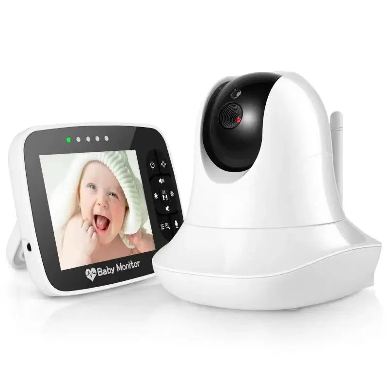 A white baby monitor with a camera beside a screen displaying a smiling baby. The screen has control buttons on its side and a heart-shaped logo below.