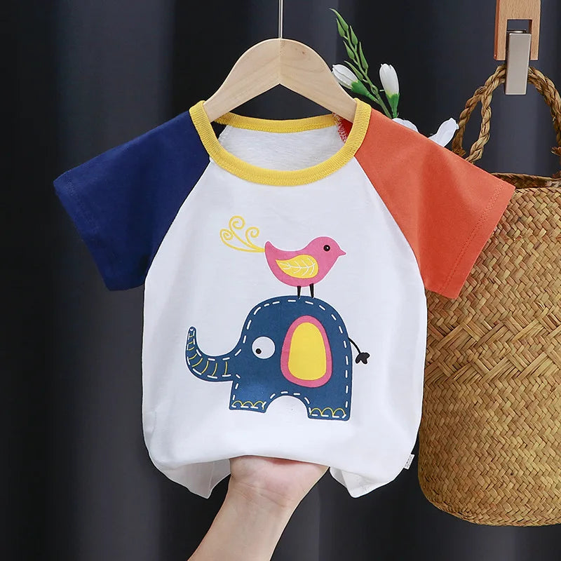 Colorful children's t-shirt with blue and orange sleeves, featuring a playful design of a pink bird standing on a whimsical blue elephant, held by a hand on a wooden hanger.
