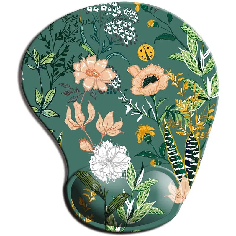 Floral-patterned mouse pad with a wrist rest. The design features various flowers and leaves in green, peach, white, and yellow, set against a dark green background.