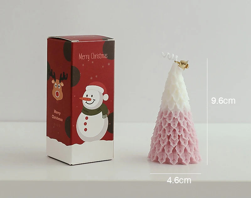 Christmas-themed candle in the shape of a pink and white tree, measuring 9.6cm tall, next to a red box with snowman and reindeer illustrations labeled "Merry Christmas."