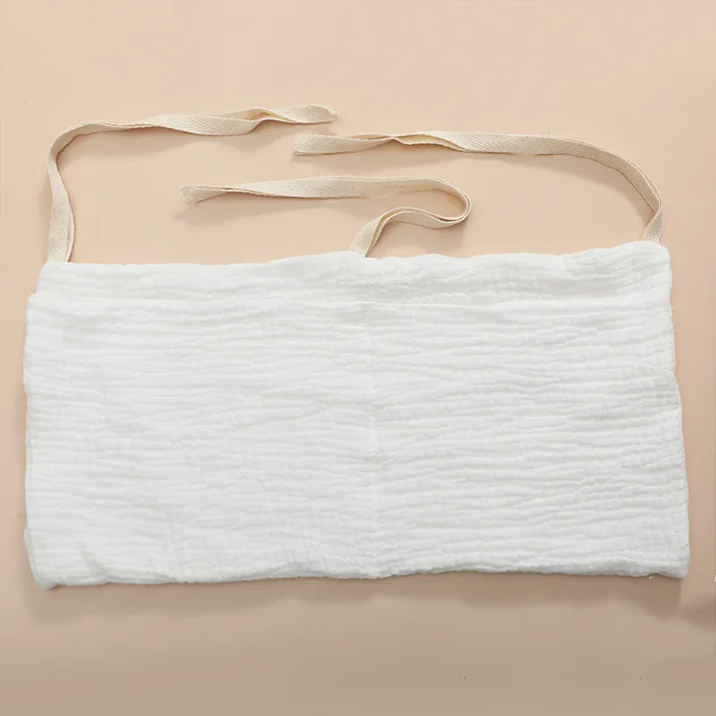 White, textured cloth mask with two beige straps on a neutral background, designed for wraparound use.
