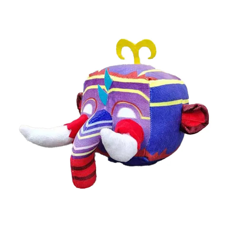 Colorful plush toy with a cubical shape, featuring a vibrant mask design. It has striped tusks, large ears, and decorative yellow and blue patterns on a purple background.